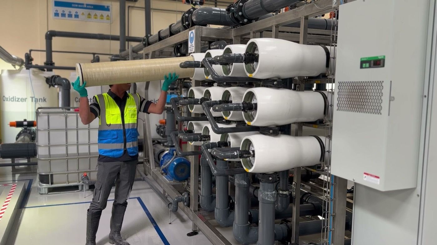 Operator in PPE loading an element into a pressure vessel